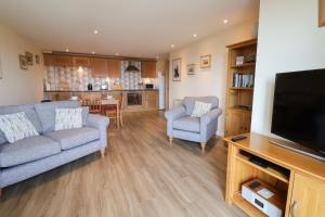 ein Wohnzimmer mit einem Sofa und einem TV in der Unterkunft 5 Buckfields in Lyme Regis