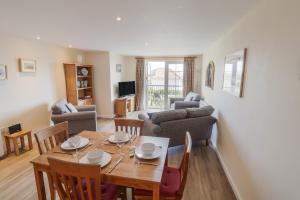 a dining room and living room with a table and chairs at 5 Buckfields in Lyme Regis
