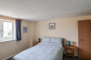 Schlafzimmer mit einem Bett und einem Fenster in der Unterkunft 5 Buckfields in Lyme Regis