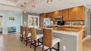 a kitchen with a large island with bar stools at 829 Napoli in Punta Gorda +36 photos