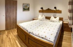 a bedroom with a large bed with a wooden headboard at Maurerhof in Ruhpolding