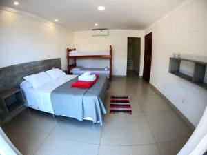 ein Schlafzimmer mit einem Bett mit einer roten Decke in der Unterkunft Hospedagem do Gaúcho in Búzios