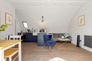 a living room with a blue chair and a table at Nestledstays- The Lake House in Arundel