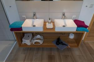 two sinks on a wooden counter in a bathroom at Wohnung Bodetal in Thale