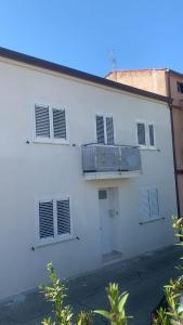 um edifício branco com janelas e uma varanda em DomusEli em Santa Maria di Castellabate