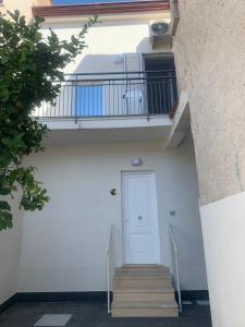 un edificio blanco con una puerta blanca y escaleras en DomusEli en Santa Maria di Castellabate