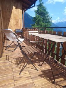 a table and chairs on a deck with a view at Un balcone sulla Val di Pejo in Peio