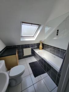 ein Badezimmer mit einer Badewanne, einem WC und einem Waschbecken in der Unterkunft Curragh View in Killybegs