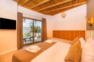 1 dormitorio con cama grande y ventana grande en Kalkan Likya Gardens en Kas