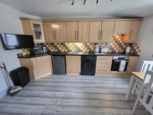 a kitchen with wooden cabinets and a washer and dryer at Curragh View in Killybegs