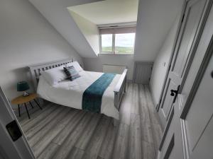 a small bedroom with a bed and a window at Curragh View in Killybegs