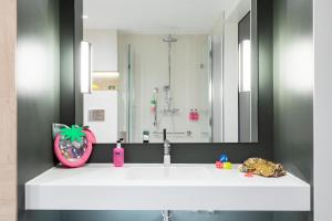 ein Badezimmer mit einem weißen Waschbecken und einem Spiegel in der Unterkunft Moxy Dresden Neustadt in Dresden