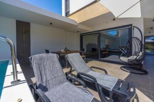 a living room with chairs and a swimming pool at House Neptunia in Medulin