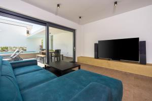 a living room with a blue couch and a flat screen tv at House Neptunia in Medulin