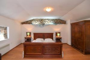 een slaapkamer met een houten bed en 2 nachtkastjes bij House Casa Barunessa in Jurdani