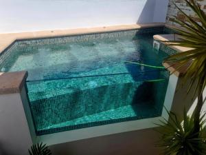 una piscina en medio de un edificio en La Casa Junto al Sendero del Río & Chimenea y leña incluida, en Los Romeros