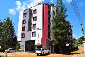Casabella Apartment - Pristine Homes,Tom Mboya في كيزيمو: مبنى فيه سيارات تقف امامه