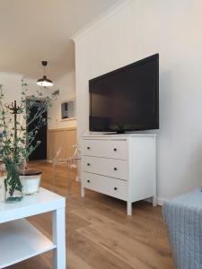 a living room with a flat screen tv on a white dresser at Apartament przy Wieży in Toruń