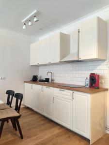 eine Küche mit weißen Schränken sowie einem Tisch und Stühlen in der Unterkunft Apartament przy Wieży in Toruń