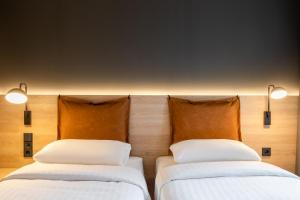 2 Betten nebeneinander in einem Zimmer in der Unterkunft Moxy Dresden Neustadt in Dresden