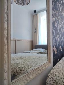 a mirror in a room with two beds and a window at Apartament przy Wieży in Toruń