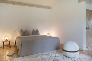 a white bedroom with a large bed and a white orb at Château Gautoul in Puy-lʼÉvêque