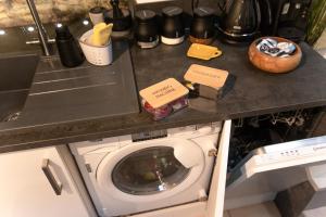 eine Küchentheke mit einer Waschmaschine in der Küche in der Unterkunft Luxury Bumblebee Cottage Frome Longleat Aqua Sana Bath DOG FREEndly in Frome