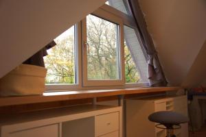 ventana en una habitación con escritorio y taburete en Ferienhaus Hieve, 