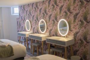 a room with three sinks and mirrors on a wall at Blackpool Abode - Beach Garden Apartment in Blackpool