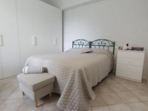 1 dormitorio blanco con 1 cama y 1 silla en Elicriso, en Gallicano