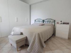 a white bedroom with a bed and a chair at Elicriso in Barga