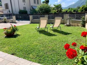 tres sillas sentadas en un patio con flores rojas en Elicriso, en Gallicano