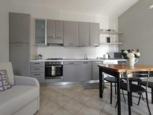 a kitchen with white cabinets and a table and a couch at Elicriso in Barga