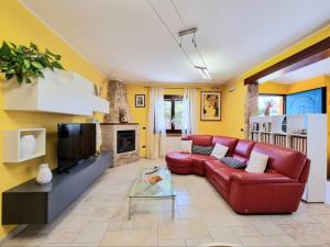 ein Wohnzimmer mit einem roten Sofa und einem TV in der Unterkunft lovely house with garden in La Maddalena