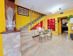 ein Esszimmer mit einem Tisch und einer gelben Wand in der Unterkunft lovely house with garden in La Maddalena