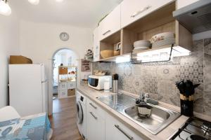 a kitchen with a sink and a refrigerator at Sea la Vie - Spiaggia Voltri in Genoa