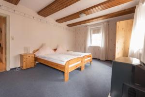 1 dormitorio con cama de madera y TV en Landhotel für Familien und Firmen en Schönhagen