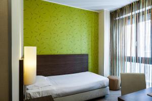 a bedroom with a bed and a green wall at Hotel Des Etrangers in Milan