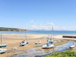 a group of boats sitting on the beach at Apartment 2, Gorwel Glas in Pwllheli