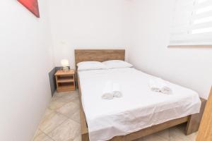 a small bedroom with a bed and a night stand at Apartment Centar in Postira