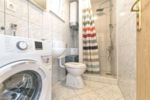 a bathroom with a washing machine and a toilet at Apartment Centar in Postira +18 photos