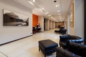 poczekalnia ze skórzanymi meblami i obrazem na ścianie w obiekcie Best Western Falck Village Milano Sesto w mieście Sesto San Giovanni