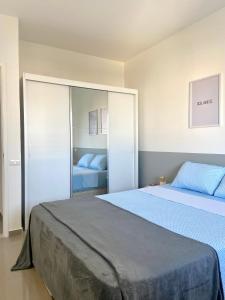 - une chambre avec 2 lits et un grand miroir dans l'établissement Apartamento renovado Barra Bella, à Rio de Janeiro