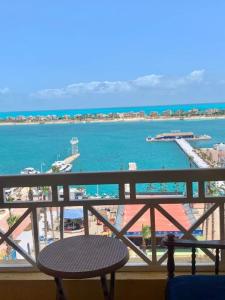 a balcony with a table and a view of the ocean at Porto Marina Rental in El Alamein +6 photos
