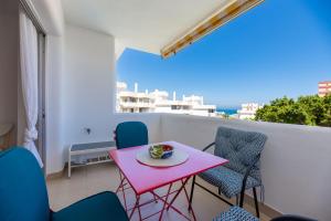 een roze tafel en stoelen op een balkon bij VB Myramar 2BDR Sun & Calm in Benalmádena