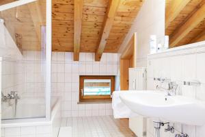 a white bathroom with a sink and a tub at Chalet Weißlofer in Reit im Winkl