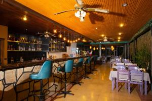 a bar with white tables and blue chairs in a restaurant at Kibele Hotel in Oludeniz