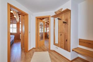 korytarz z drewnianymi drzwiami w domu w obiekcie Chalet Weißlofer w mieście Reit im Winkl