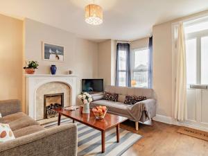 a living room with a couch and a fireplace at Harbour Walk in Brightlingsea