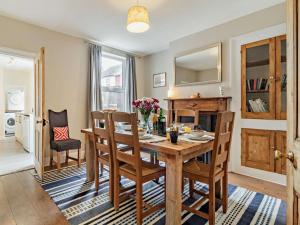 a dining room with a wooden table and chairs at Harbour Walk in Brightlingsea